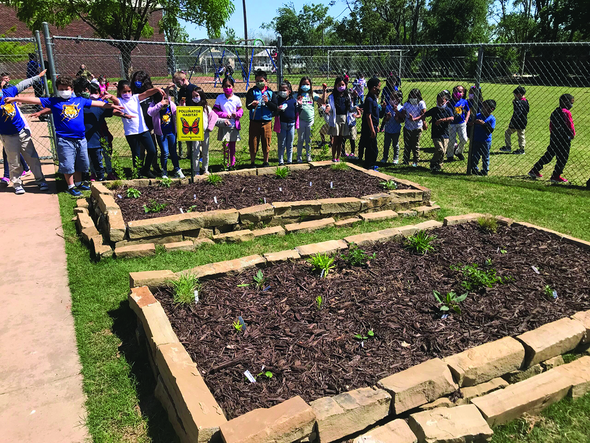 Students at Mark Twain Elementary pose for a photo with their new pollinator garden. | © Katie Hawk